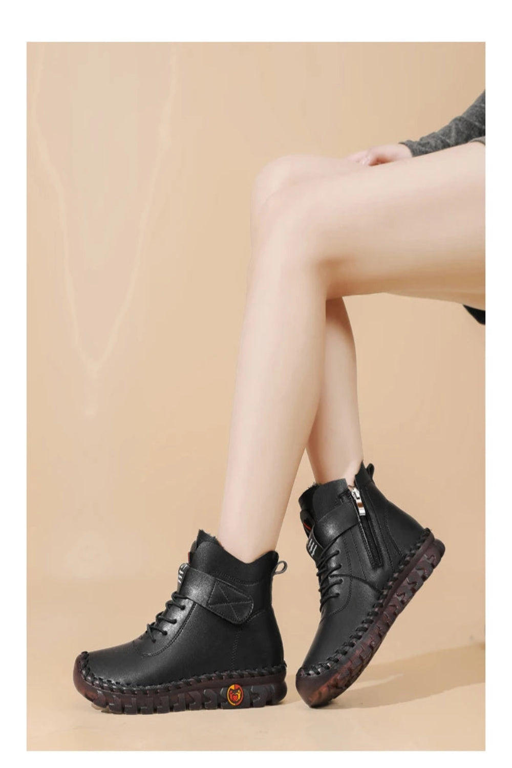 Black leather boots worn by a person on a beige background
