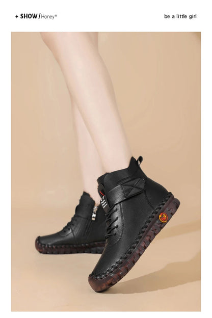 Black leather boots with brown soles on a beige background