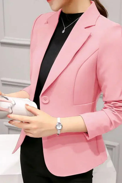Person wearing a pink blazer holding a white container with a gray background
