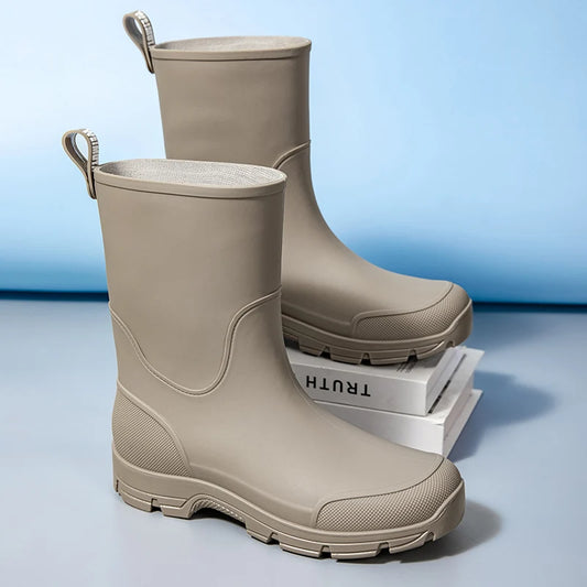 Pair of beige rubber boots on a light blue background