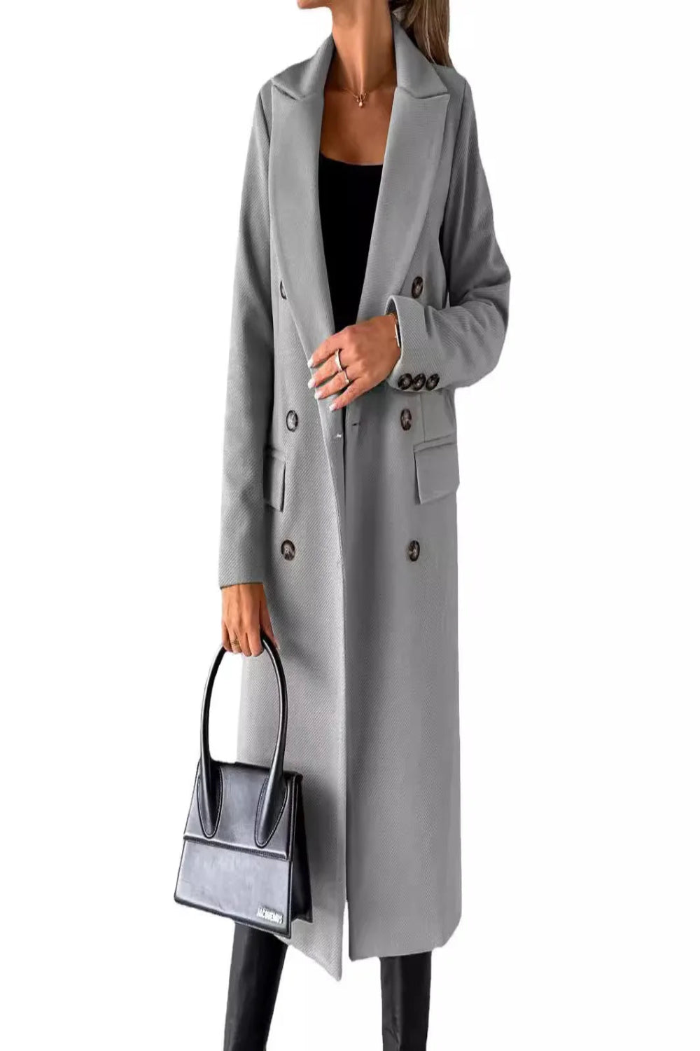 Person wearing a gray coat holding a matching handbag on a white background