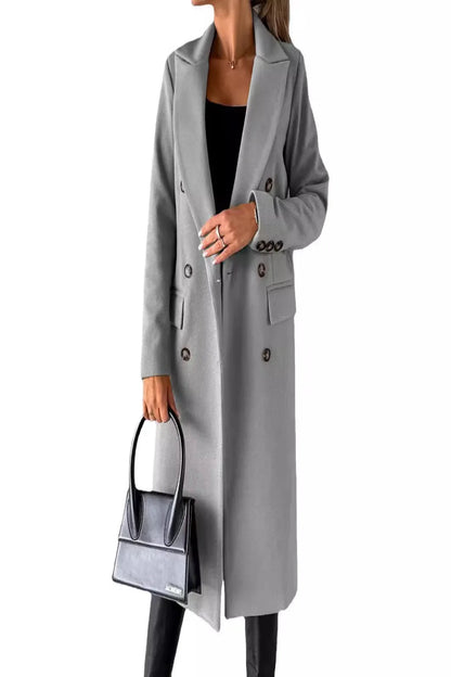 Person wearing a gray coat holding a matching handbag on a white background