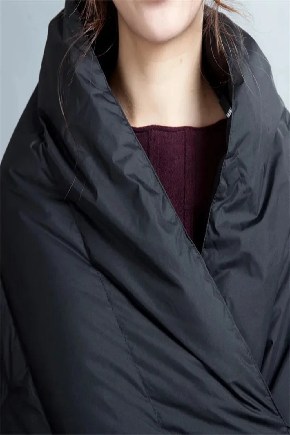 Person wearing a black puffer coat with a blurred background