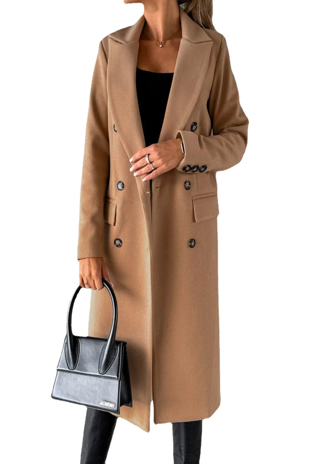 Person wearing a beige coat holding a black handbag on a white background