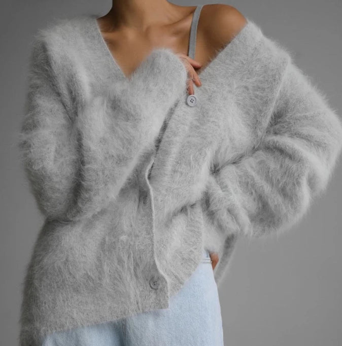 Gray cardigan worn by a person on a gray background