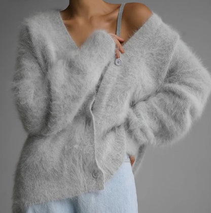 Gray cardigan worn by a person on a gray background