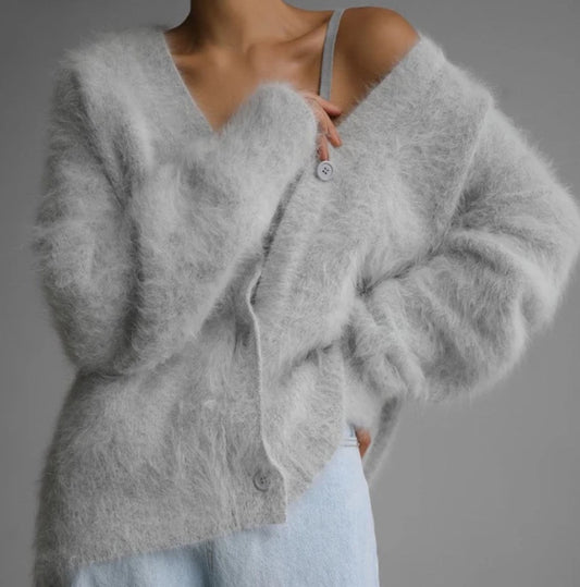 Gray cardigan worn by a person on a gray background