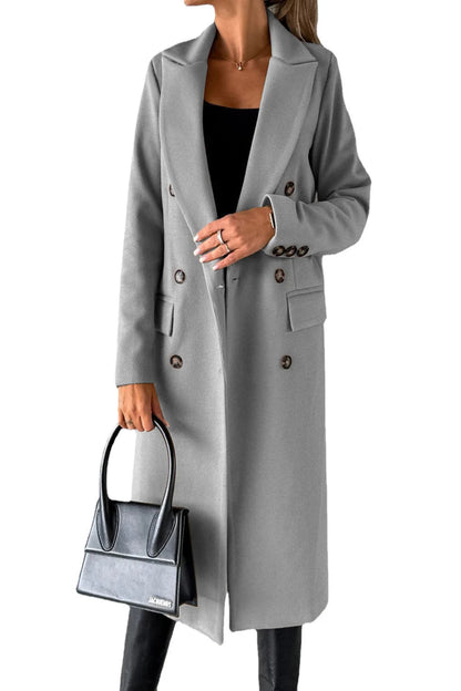 Person wearing a gray coat holding a black handbag on a white background