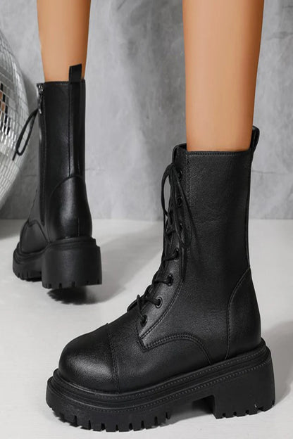 Black leather boots with thick soles on a neutral background