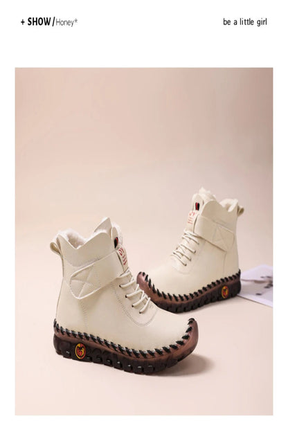 White high-top boots with brown soles on a light pink background