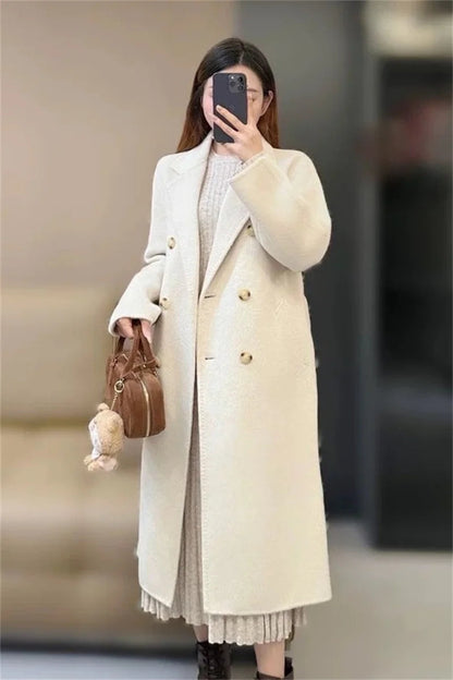 Woman wearing a long beige coat in an indoor setting