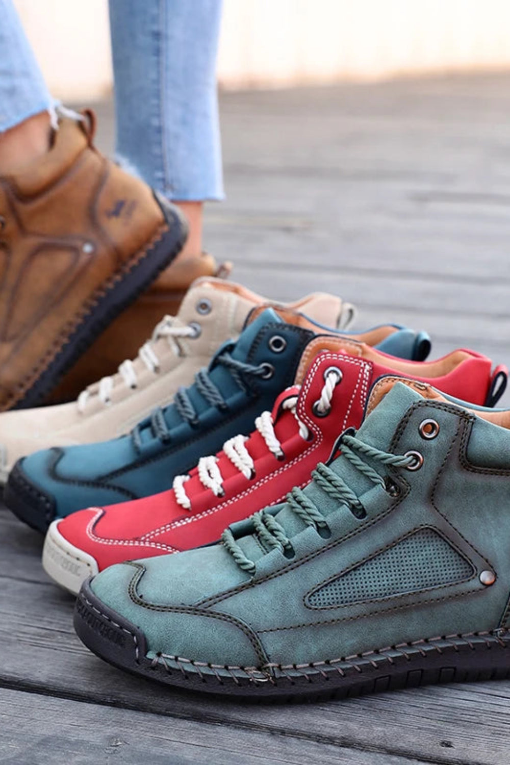 Four pairs of colorful high-top sneakers on a wooden floor.