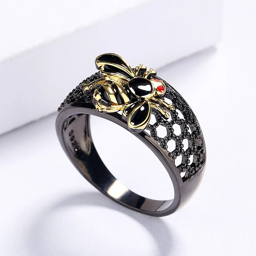Gold and silver bee-shaped ring on a white background