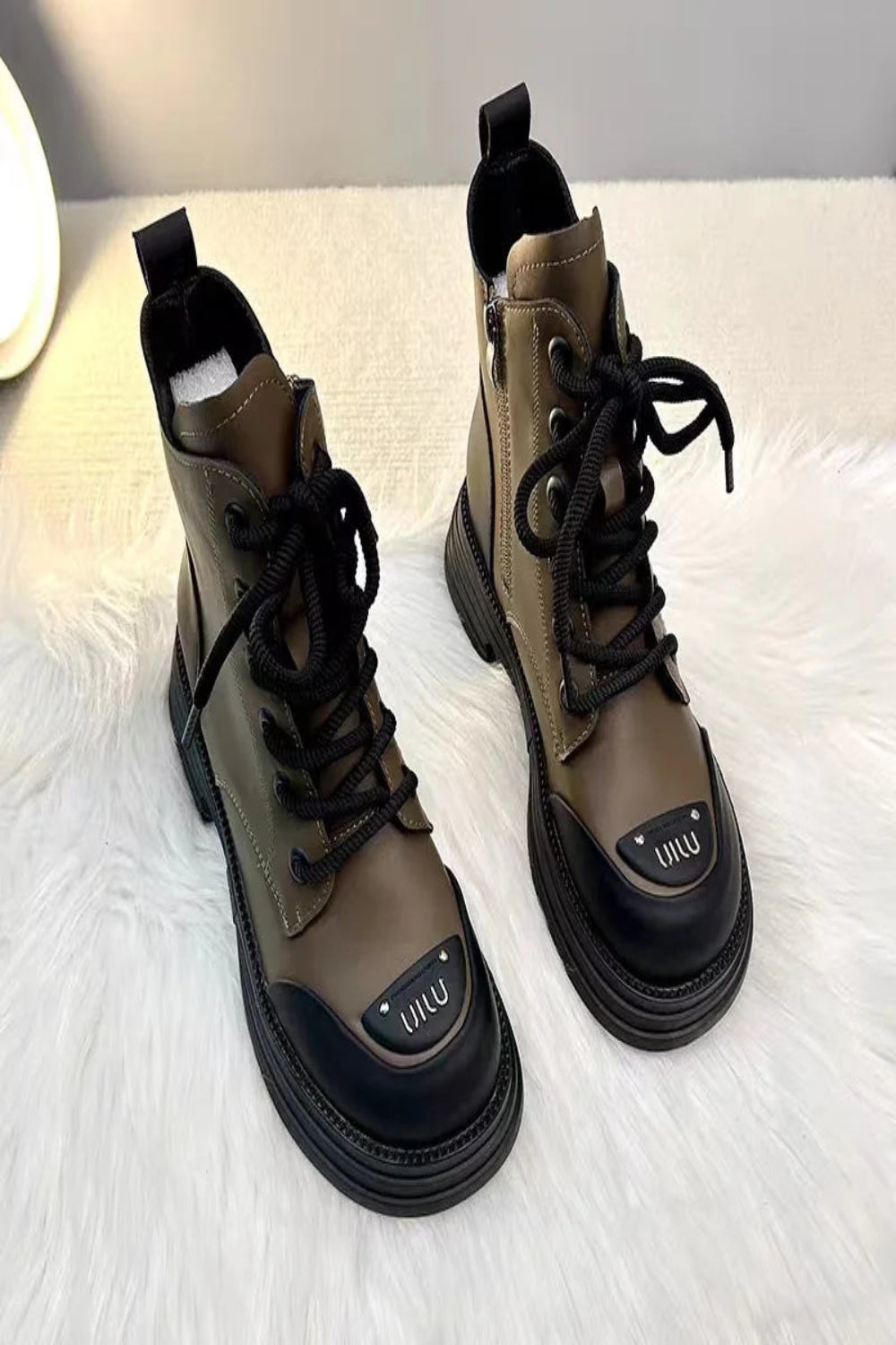 Pair of brown and black boots with a visible brand logo on a white surface.