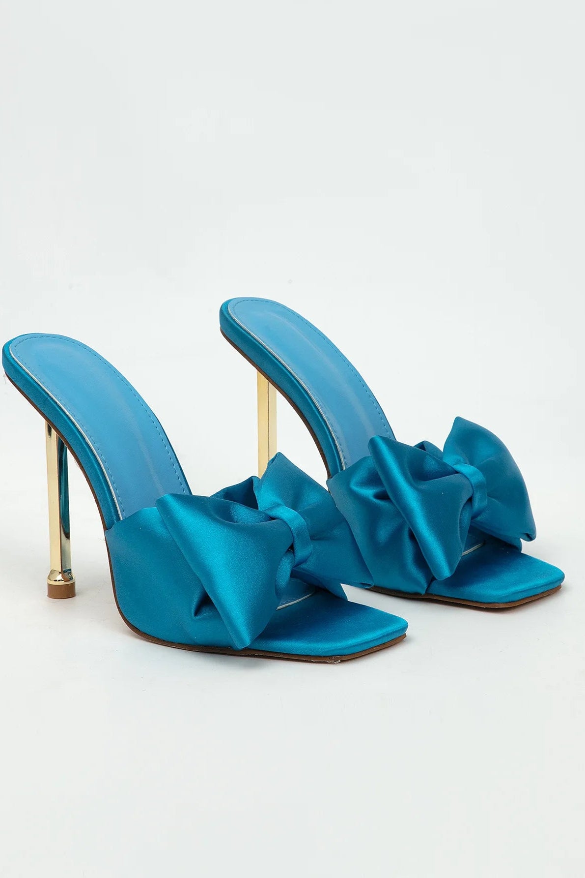 Blue high-heeled shoes with large bows on a white background