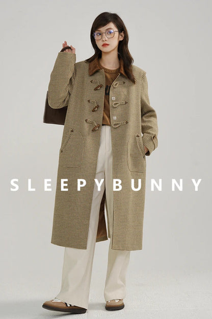 Person wearing a long beige coat with 'Sleepy Bunny' branding