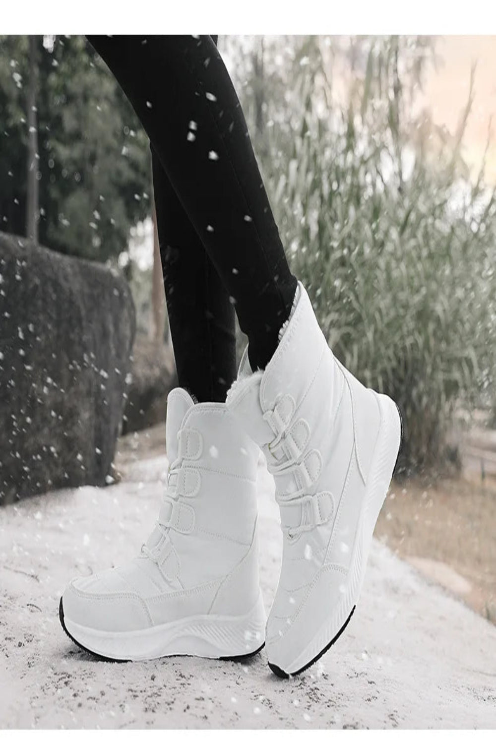 White winter boots worn outdoors with snowflakes falling