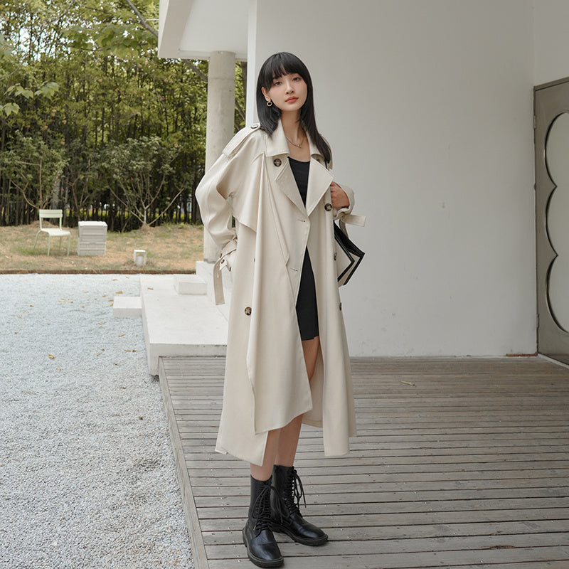 Woman wearing a beige trench coat in an outdoor setting