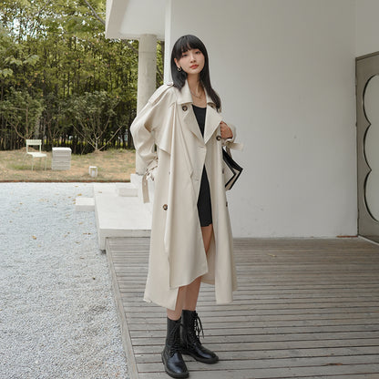 Woman wearing a beige trench coat in an outdoor setting