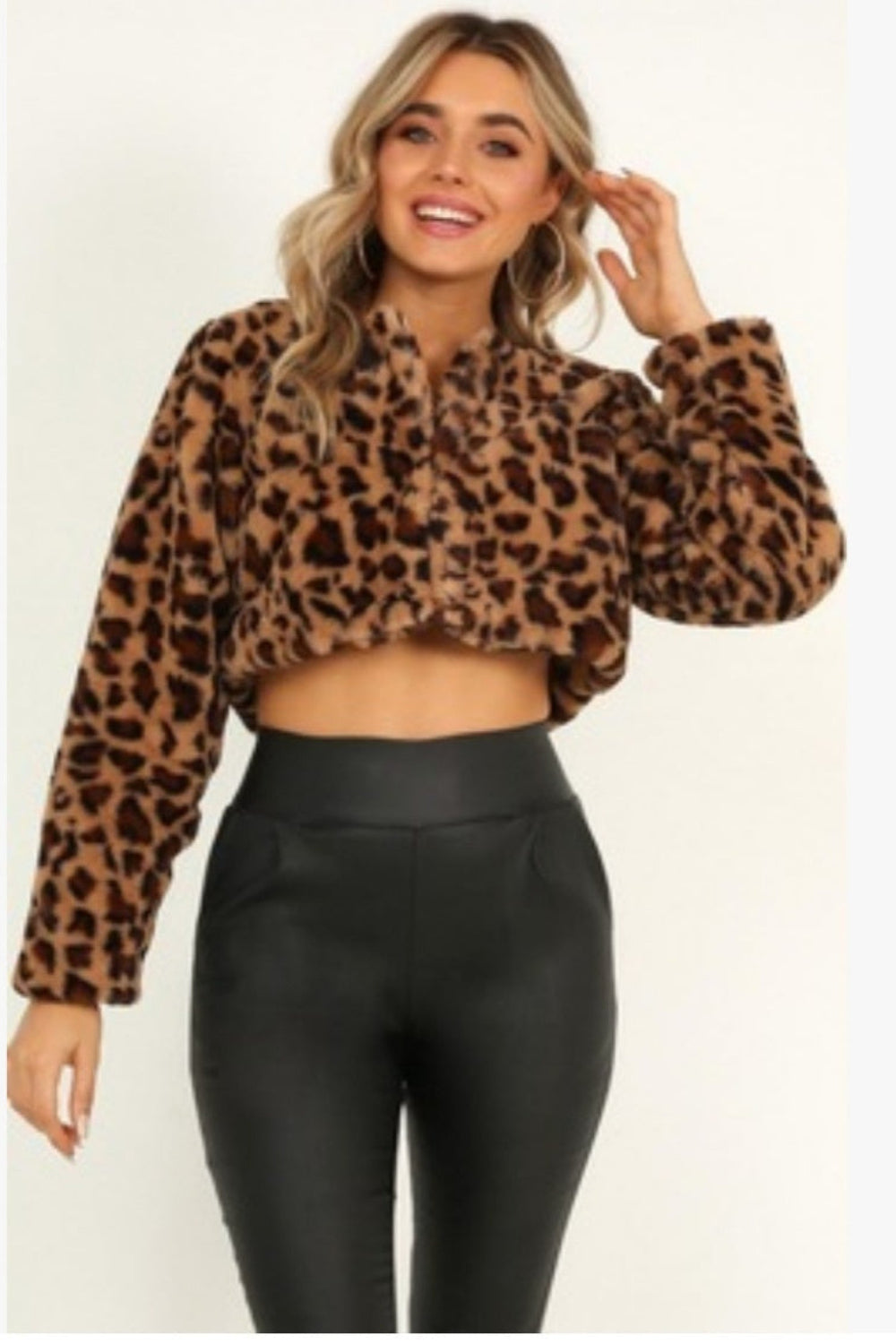Woman wearing a leopard print hoodie and black pants on a white background