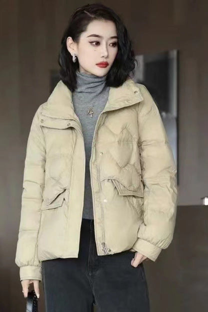 Woman wearing a beige puffer jacket in an indoor setting