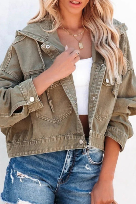 Person wearing an olive green jacket and blue jeans against a white background