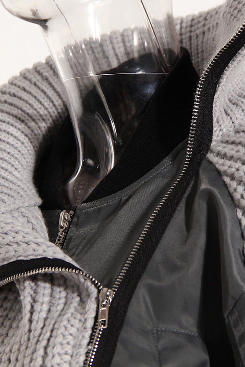 Gray knit cardigan with a black interior lining on a mannequin against a white background