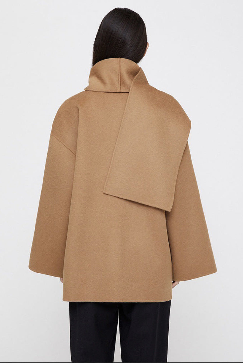 Beige coat worn by a person on a white background