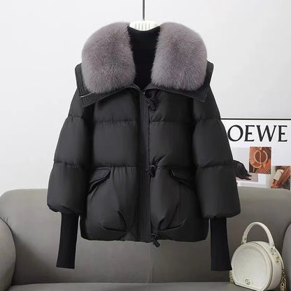 Black puffer jacket with gray fur collar on a gray sofa