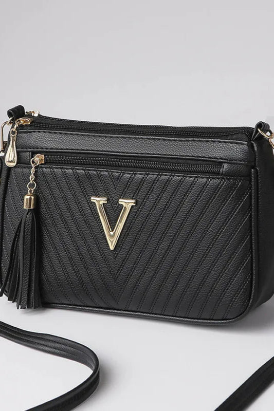 Black handbag with gold accents on a light gray background