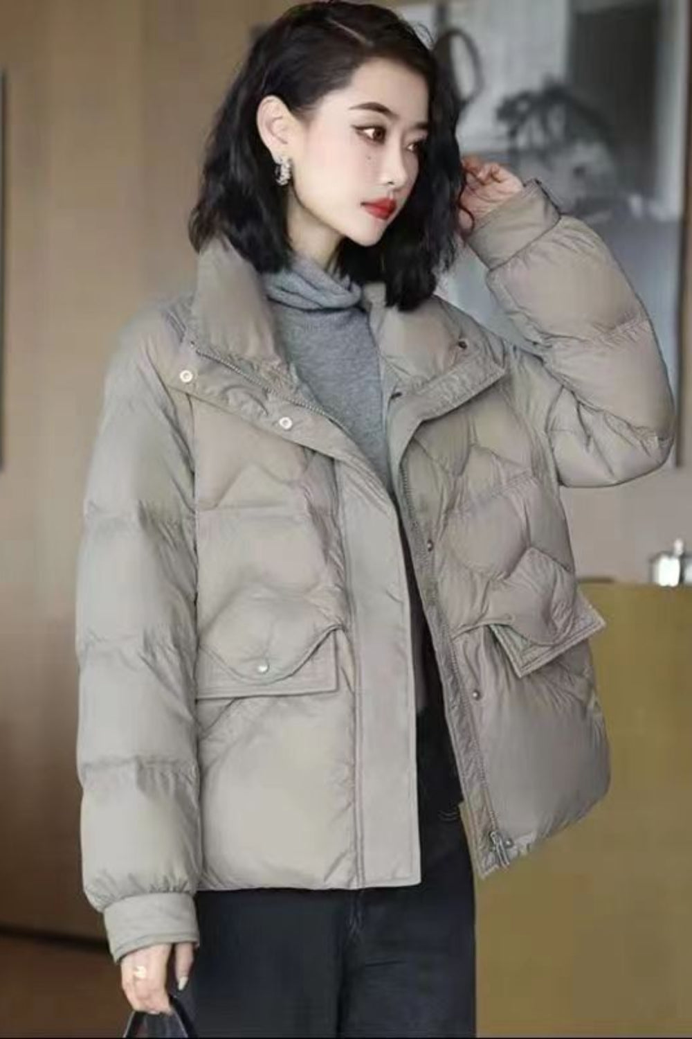 Woman wearing a beige puffer jacket indoors