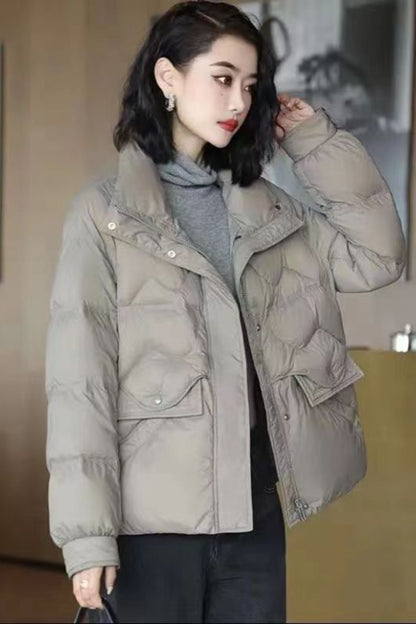 Woman wearing a beige puffer jacket indoors