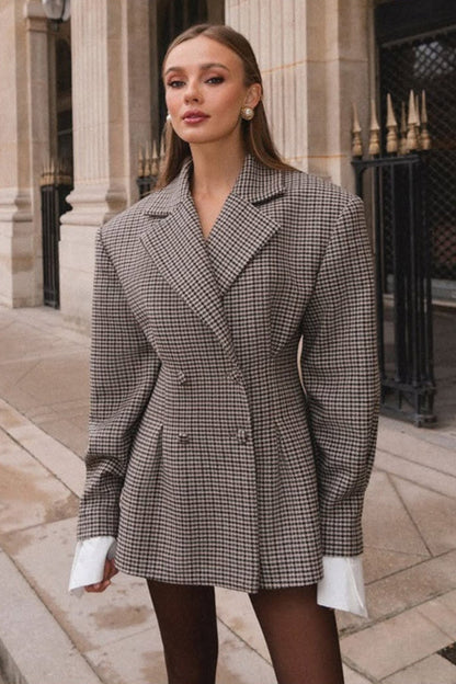 Woman wearing a checkered blazer in an urban setting