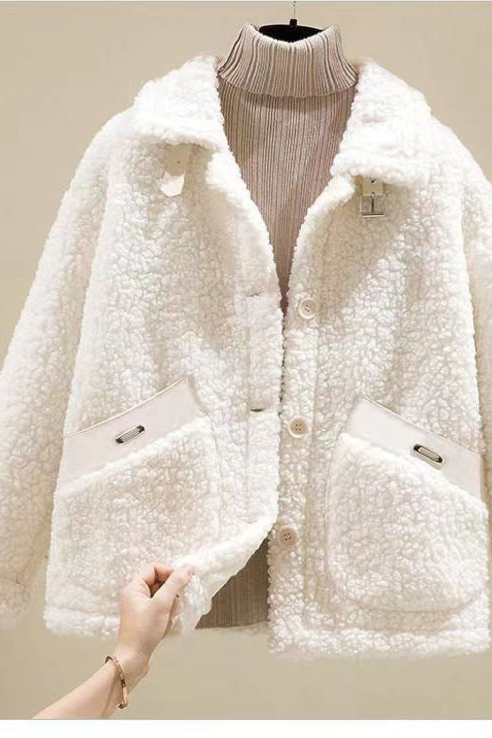 White sherpa jacket on a mannequin against a neutral background