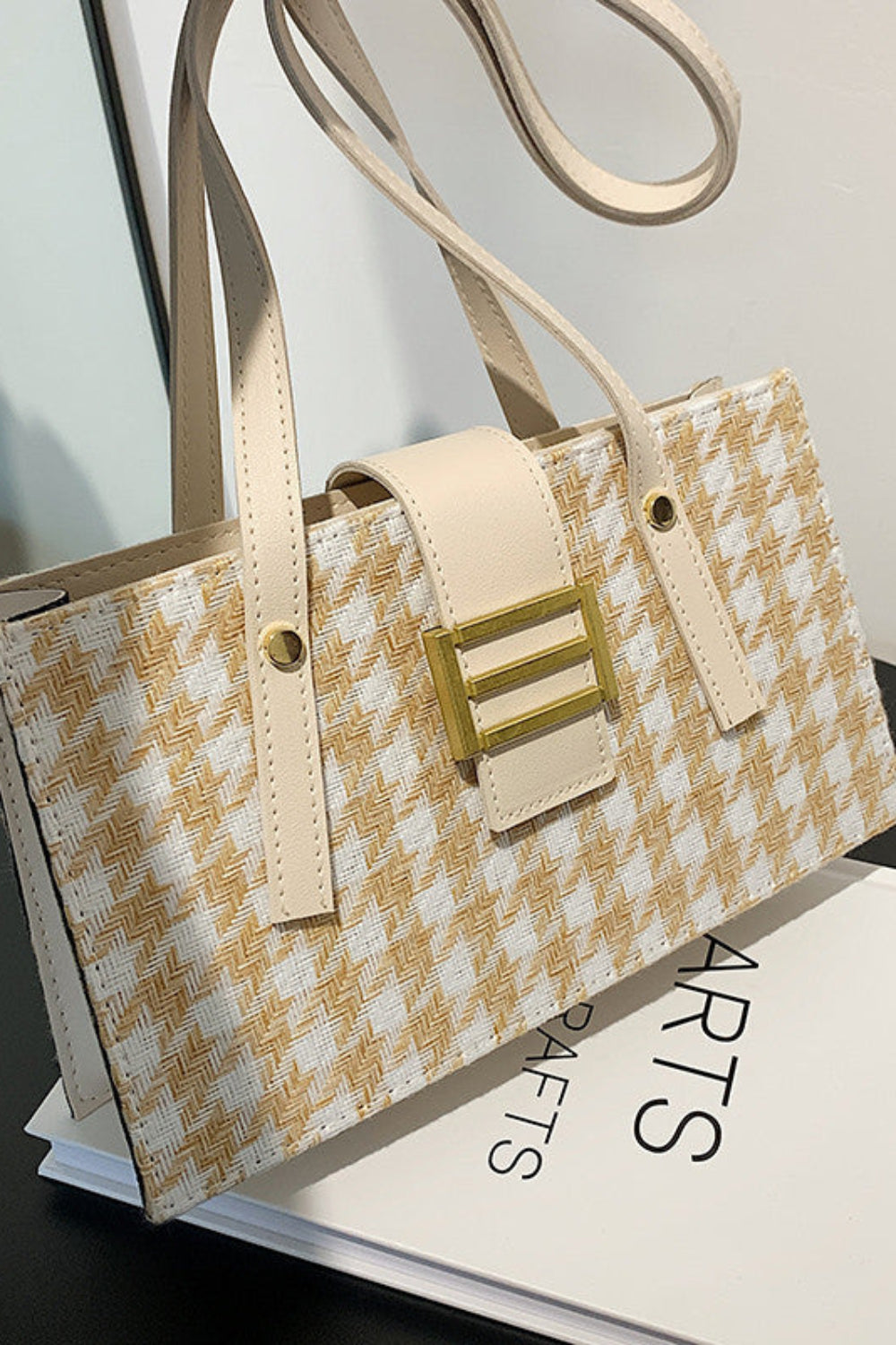 Handbag with gold accents on a black surface