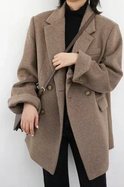 Person wearing a brown coat against a white background