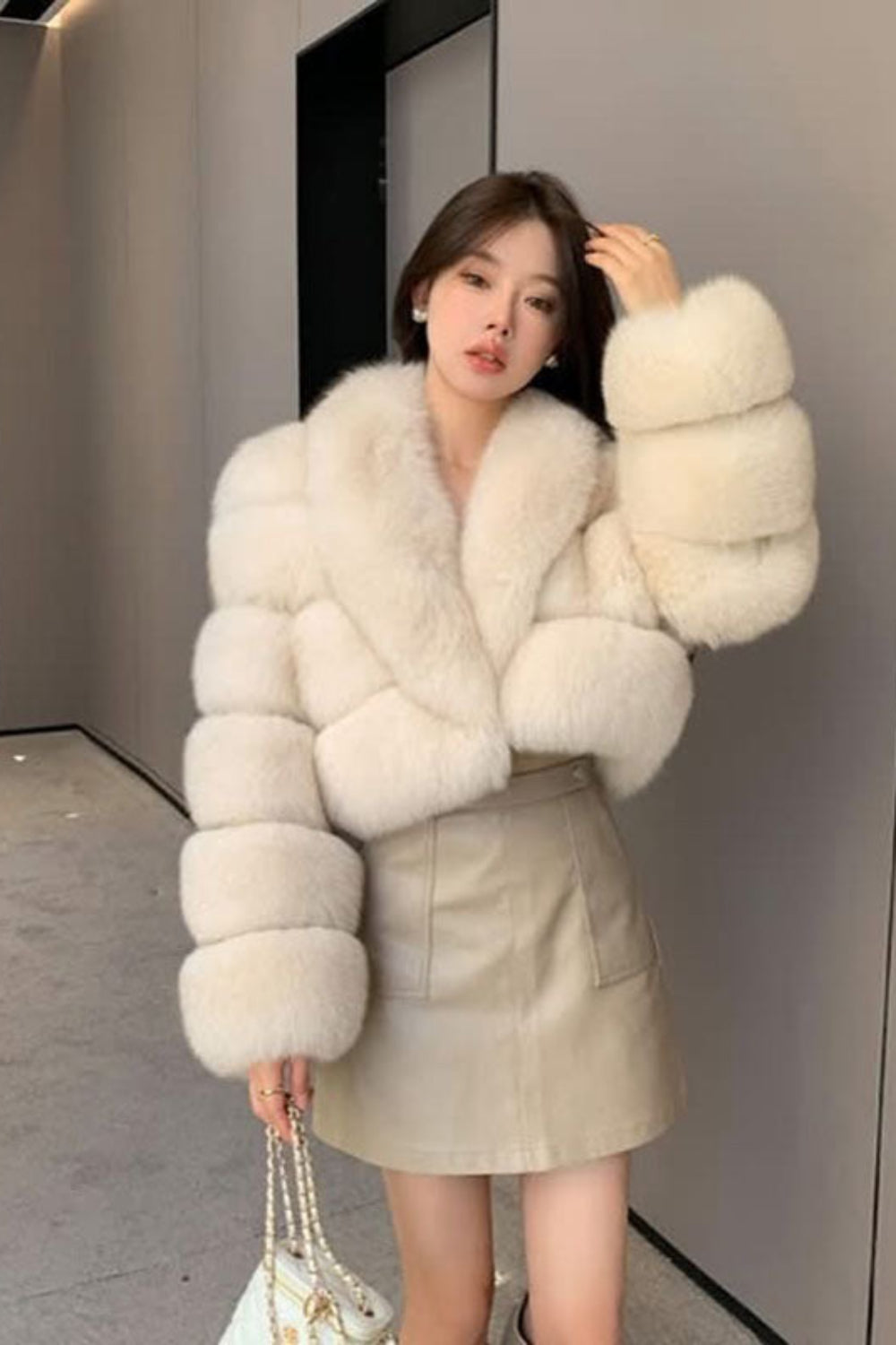 Woman wearing a white fur coat in an indoor setting