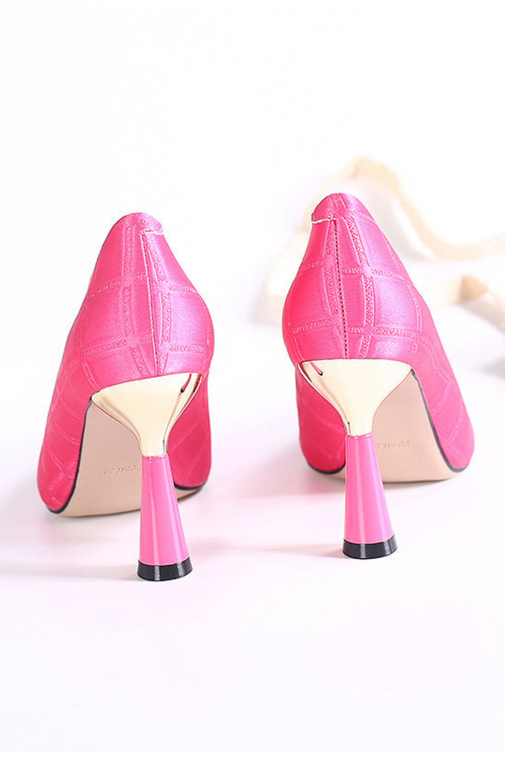 Pair of pink high-heeled shoes on a white background