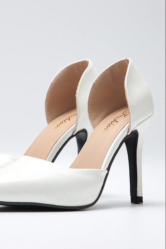 White high-heeled shoes with black soles on a light gray background