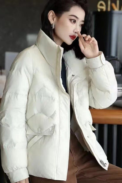 Woman wearing a white puffer jacket in an indoor setting