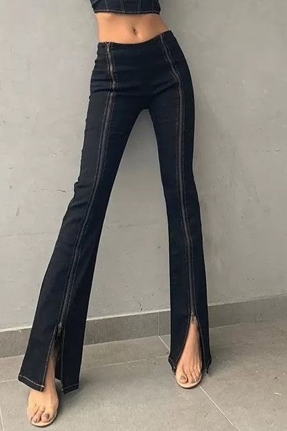 Black flared jeans worn by a person on a gray background