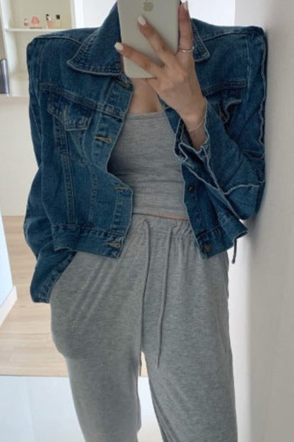 Person wearing a denim jacket and gray outfit taking a mirror selfie.