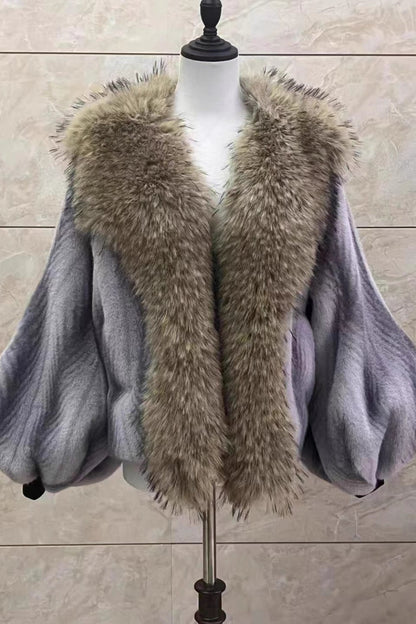 Gray coat with a fur collar on a mannequin against a beige tiled wall.