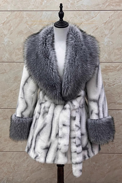 Fur-trimmed coat on a mannequin against a beige marble background