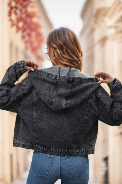 Person wearing a black denim jacket with a blurred background