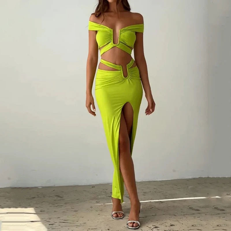 Woman wearing a bright green off-shoulder dress with a high slit on a plain background