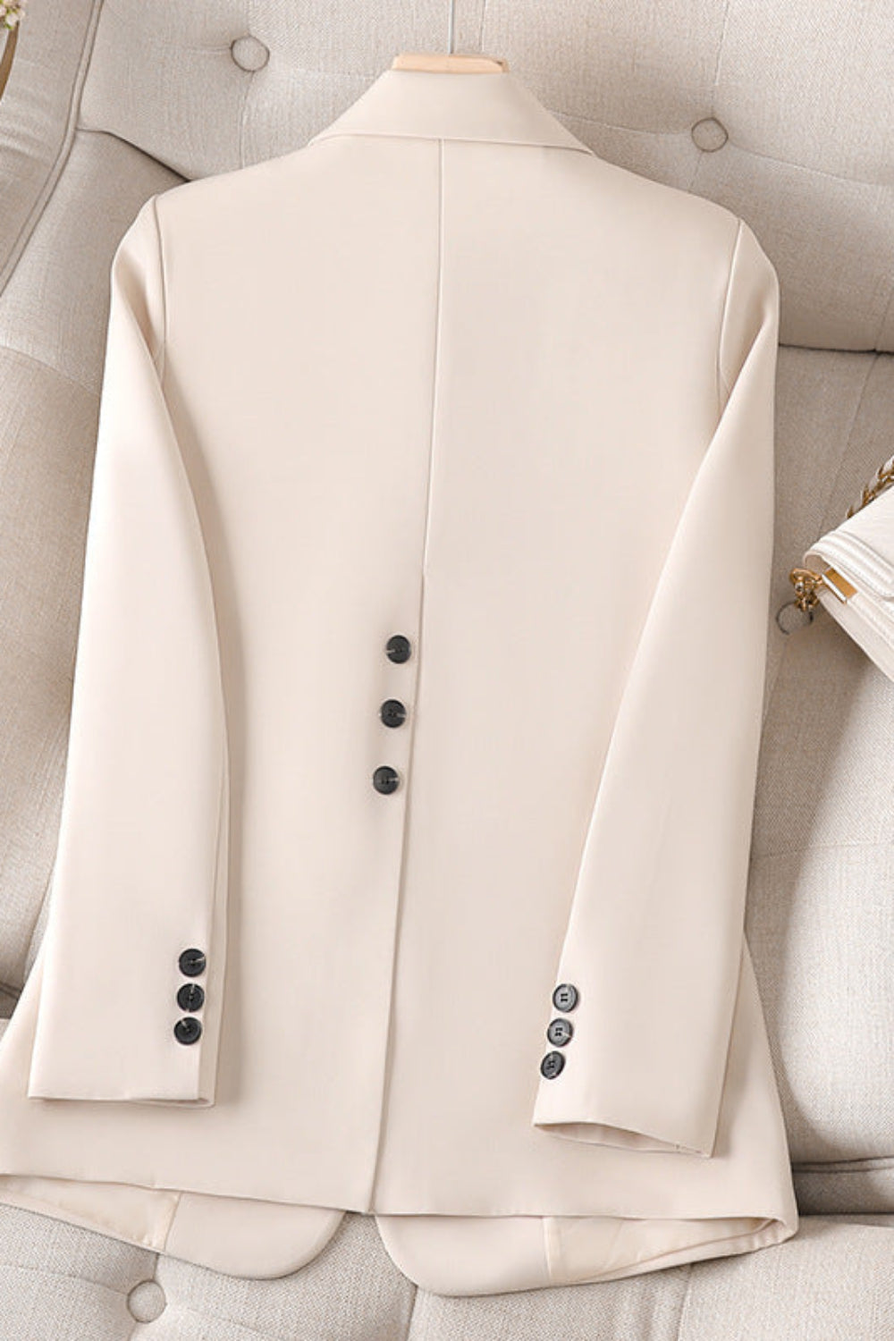 Beige suit jacket on a mannequin against a neutral background