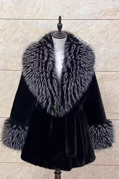 Black fur coat with silver fox fur collar on a mannequin against a beige background