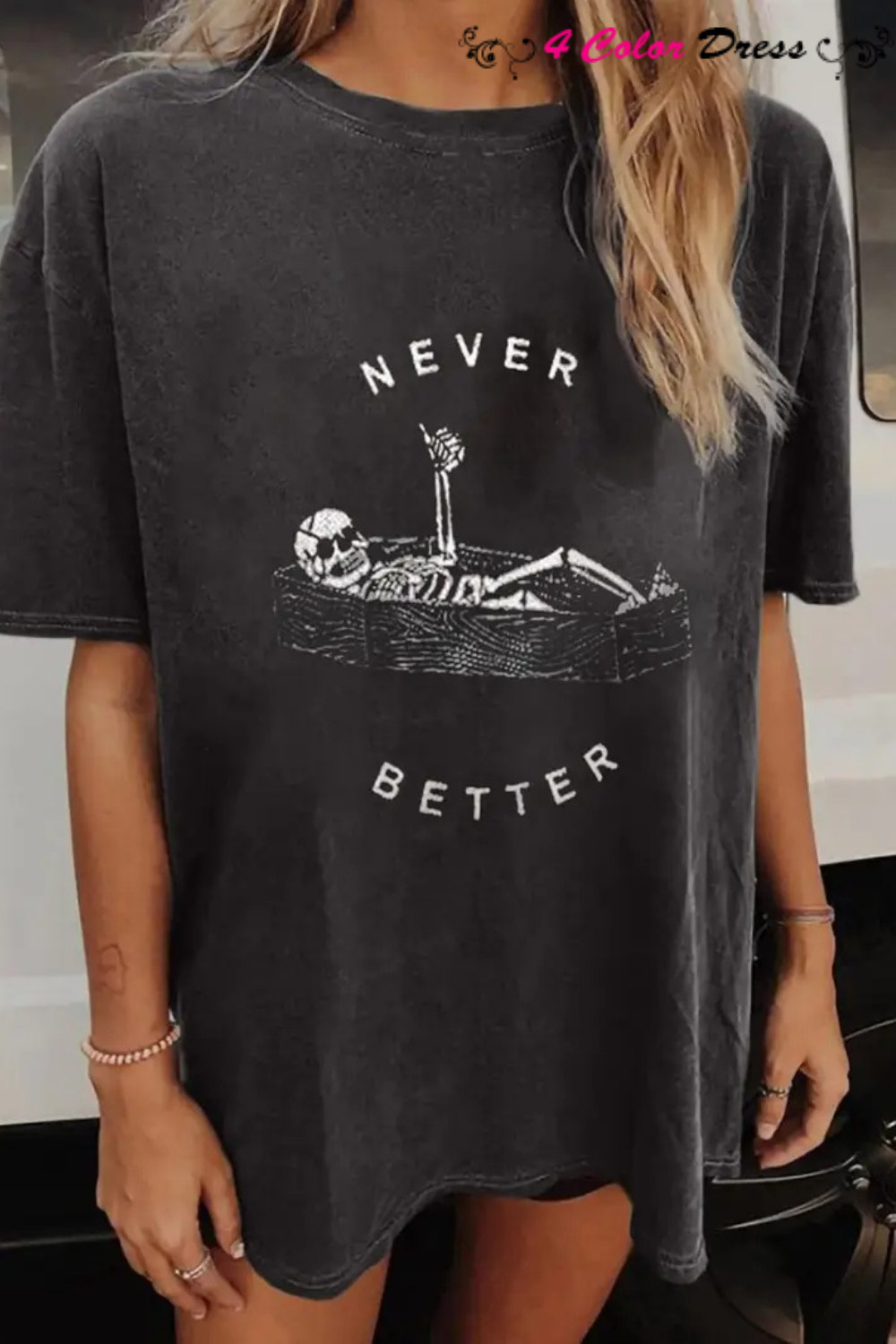 A woman wearing a gray t-shirt with a graphic that includes a skull and the text 'NEVER BETTER'.